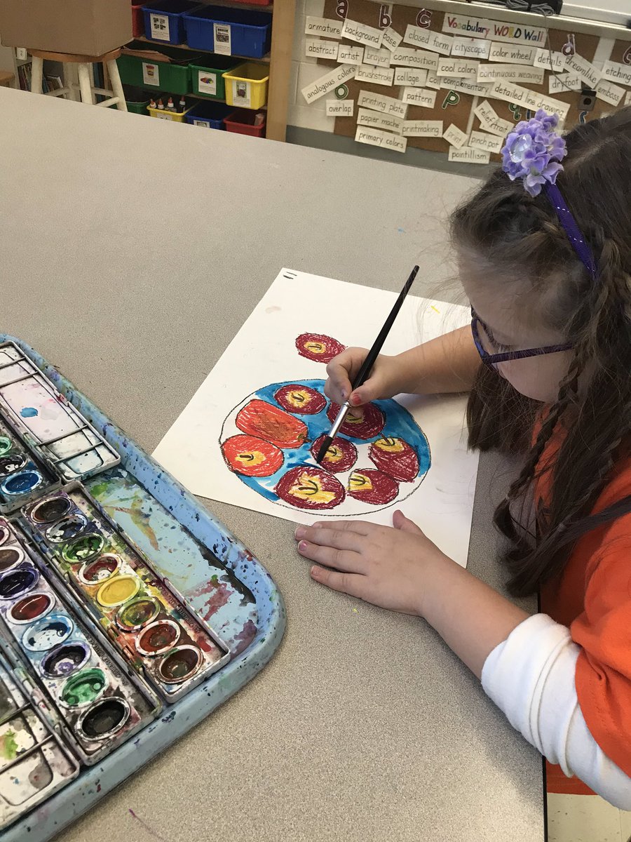 1st graders painting cool colors on their apple still lives.