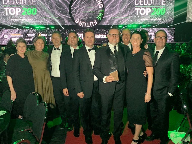 group photo of men and women dressed in formal attire at an awards show