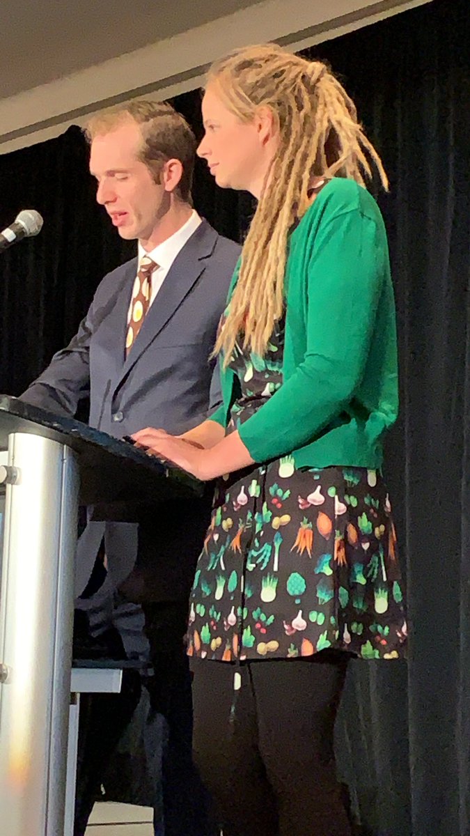 Cammy in a vegetable print dress and James with an egg design tie ...the Lockwoods are dressed to promote their farm  #dressedforsuccess #oyf2019