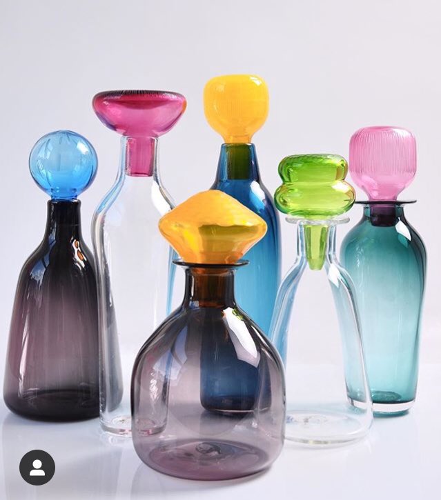 Six blown glass bottles with colourful stoppers