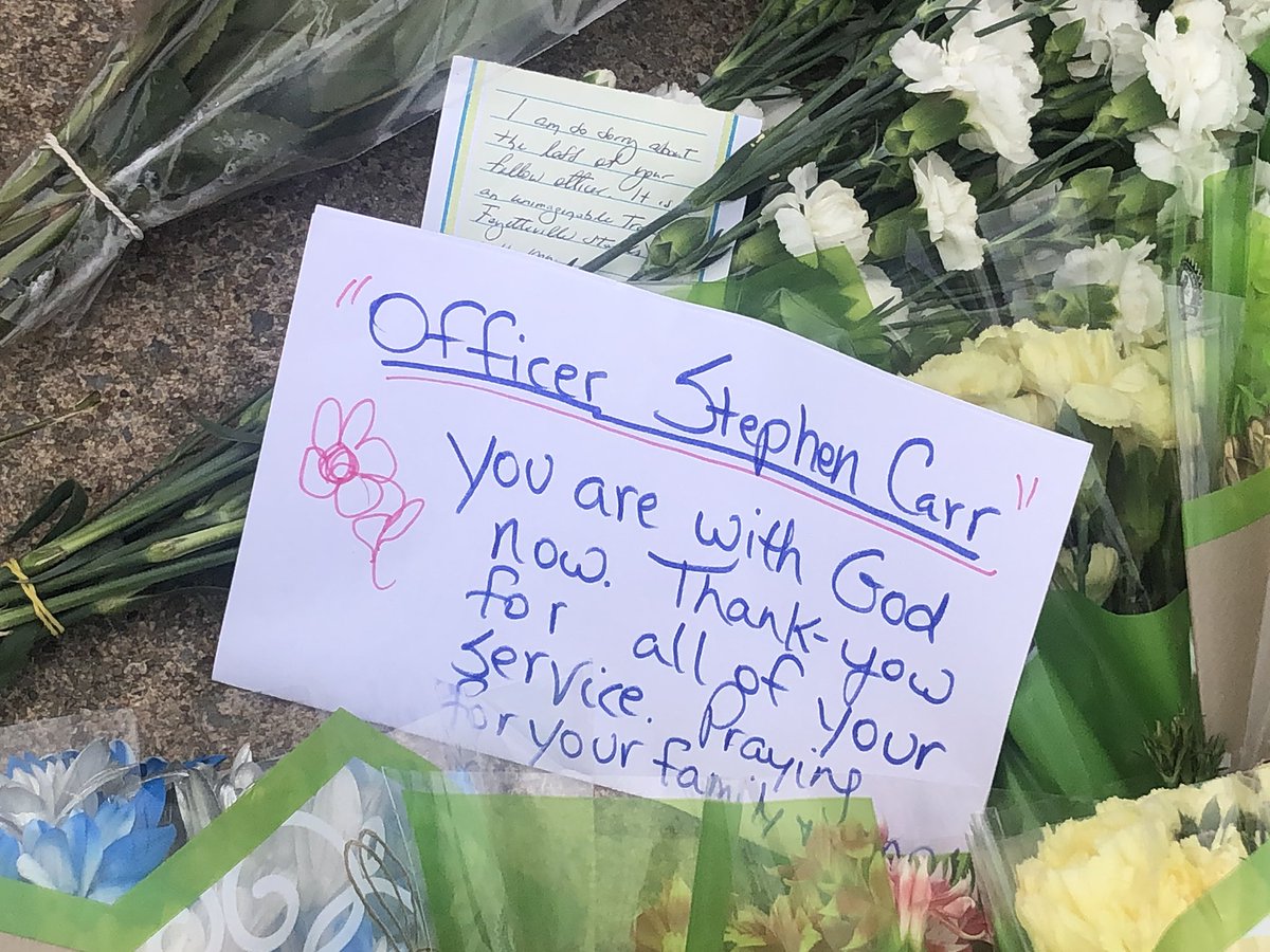 katelynngorton's tweet photo. A memorial has been set up for Stephen Carr outside of the Fayetteville Police Department.

While there, I saw people drop off flowers and hug officers.

My thoughts and prayers are with Carr’s family and the police department. https://t.co/vgvKny6YTM