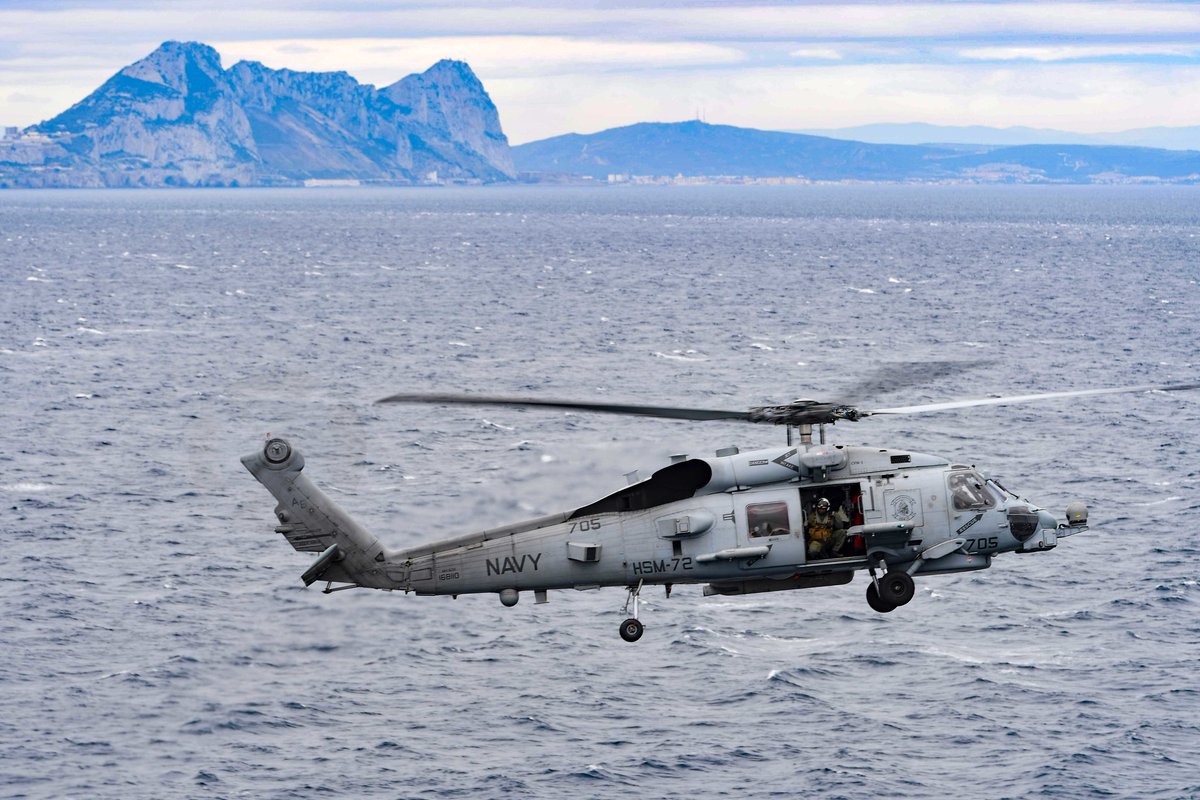 USNavyEurope's tweet photo. An MH-60R Sea Hawk helicopter attached to #HSM72 embarked aboard #USSHarrySTruman #CVN75 flies through the #StraitofGibraltar while conducting a maritime security patrol, Dec. 5. The HST CSG is conducting ops in #US6thFleet to support maritime security operations in intl waters. https://t.co/J4aJKDvb6N