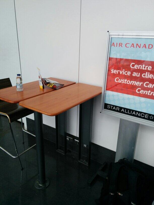 Simplest makeshift standing desk = a desk made for tall chairs/stools. Remove chair & you're good to go.Left is Montreal airport, right is  @Communitech Hub.Many airports & university buildings have tall desks like this.