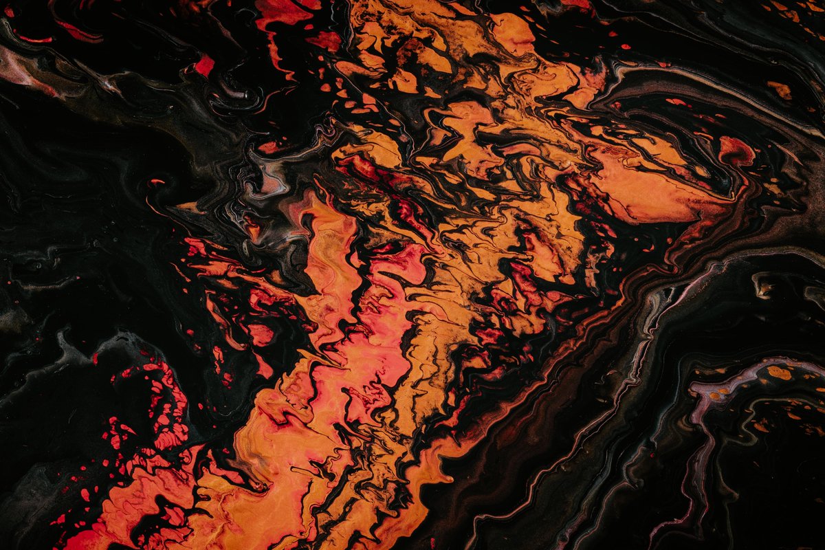 Painting of fluid orange and black colours, photographed by Paweł Czerwiński via unsplash.com.