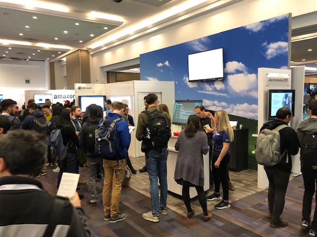 A large group of people stand at the Microsoft booth at NeurIP 2019.