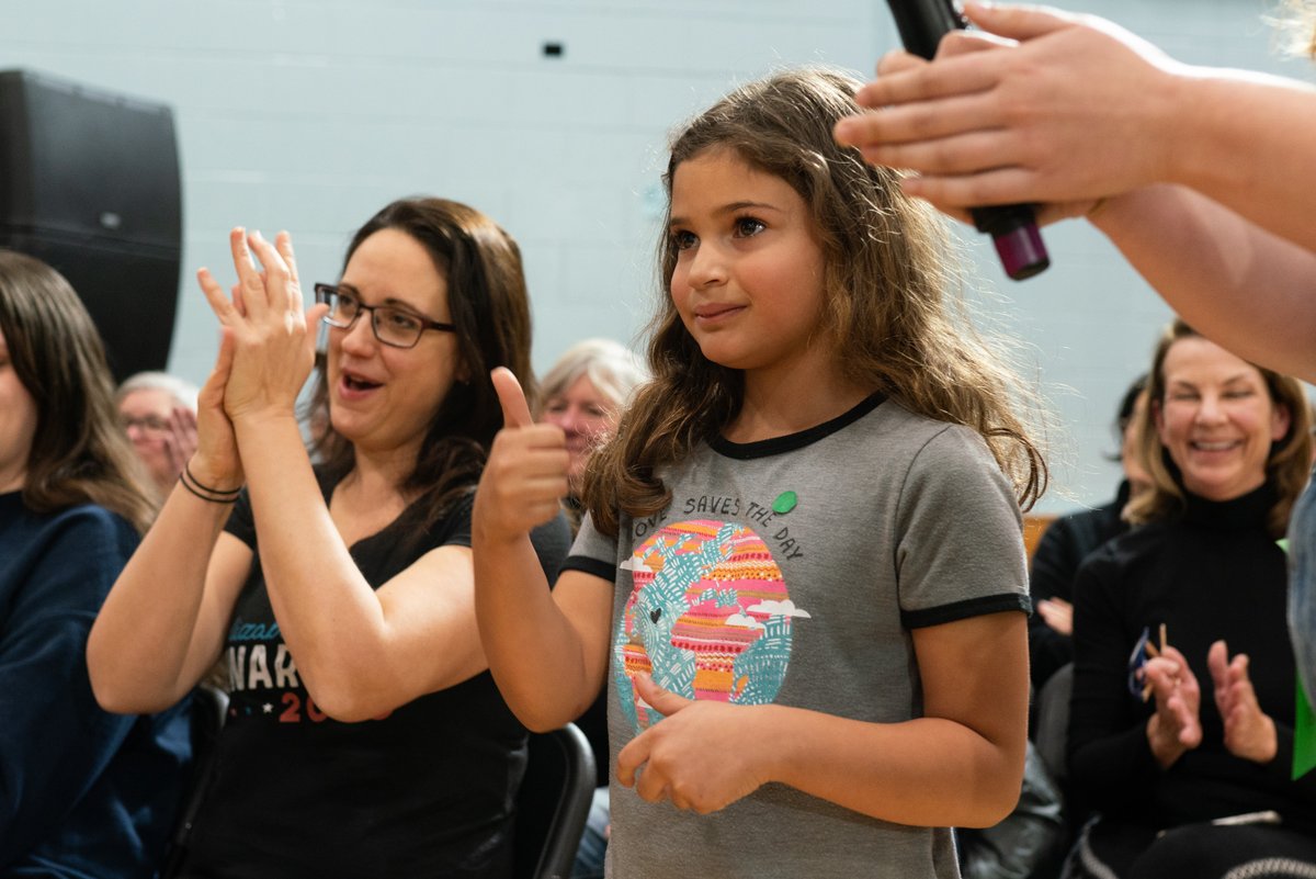 A young girl gives Elizabeth Warren a thumbs up at the Rye town hall.