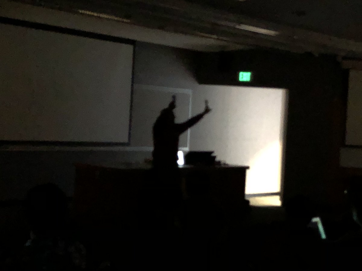 Gregory Abowd in a darkened room raising his arms above his head