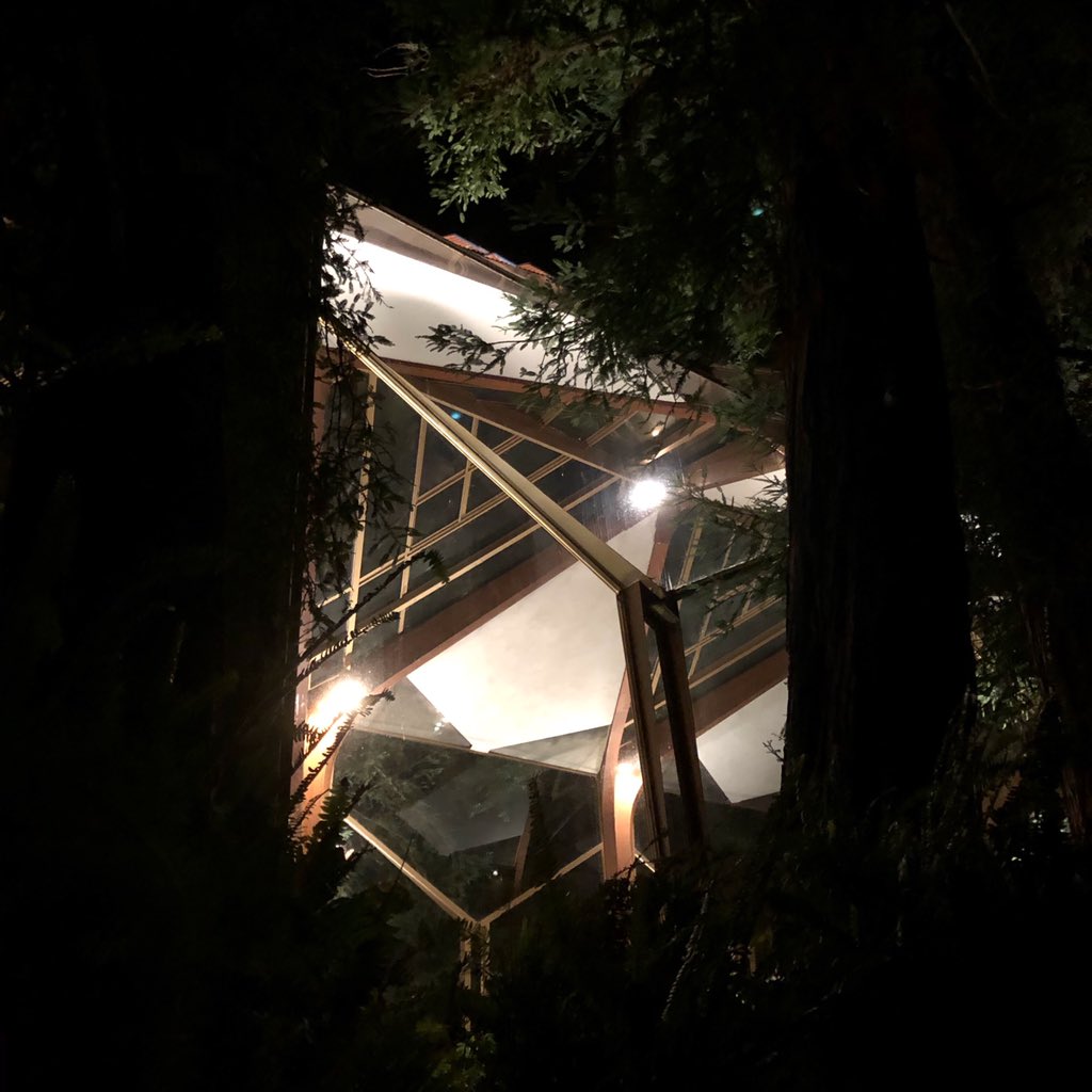 kurtkrueger's tweet image. In the evening glow of Wayfarer’s Chapel, you notice the tapered steel mullions and how the lighting reflects the ceiling onto the glass wall, giving the illusion of the cathedral ceiling extending to the space to the exterior.
#wayfarerschapel #lloydwright
#lloydwright