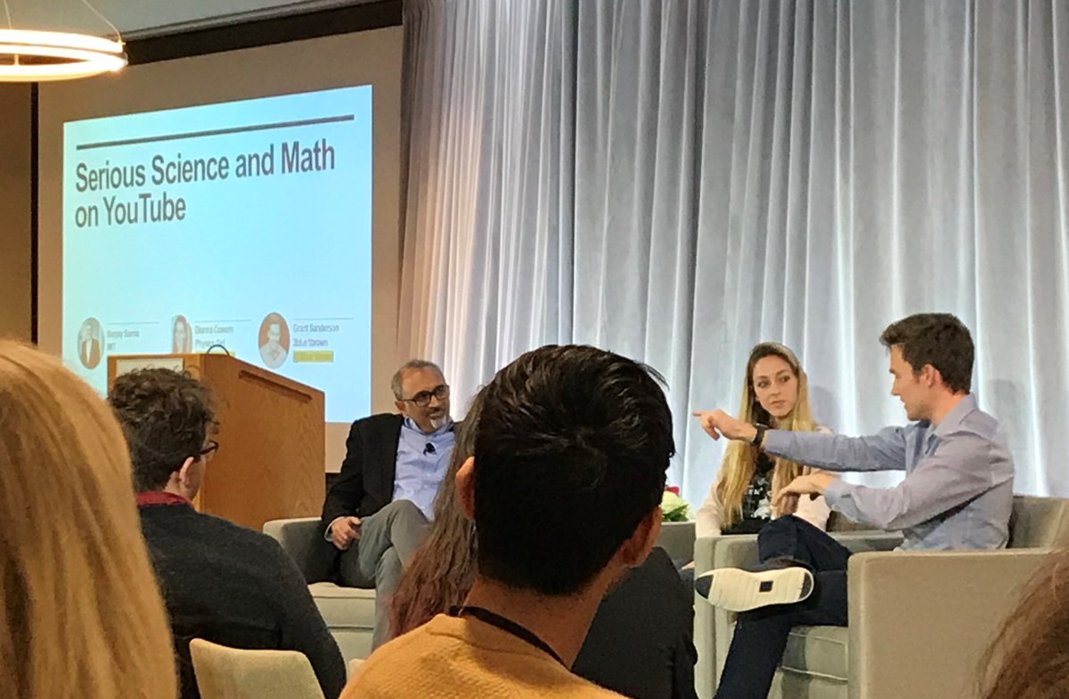 panel sitting on chairs in front of "serious science and math on YouTube" sign