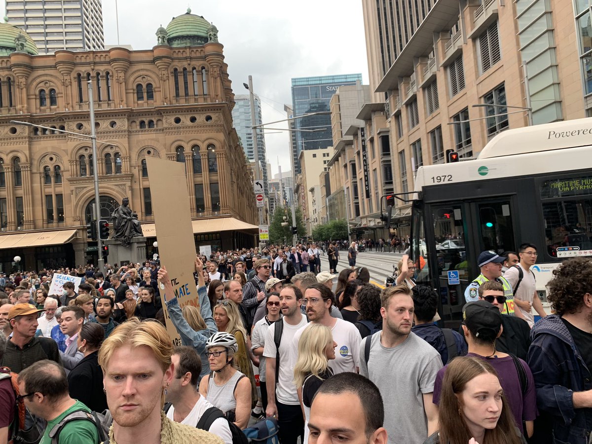More people arriving to the rally, crossing the road and slowly spreading out across 4 different city blocks.