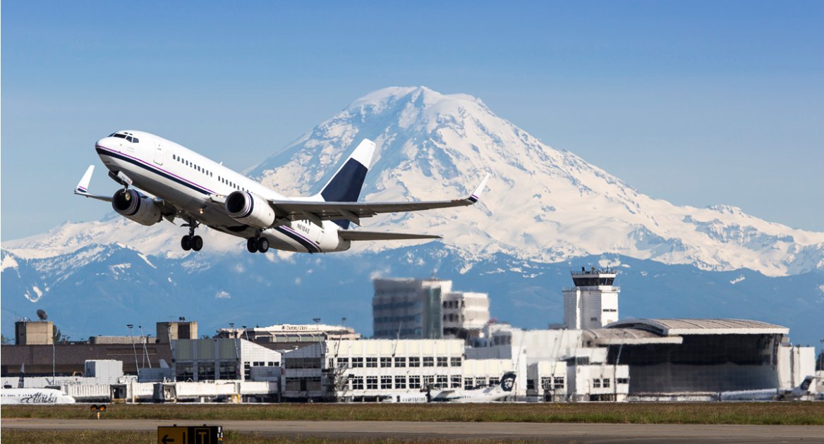 A plane takes off from SeaTac airport with Mt. Rainier in the background.