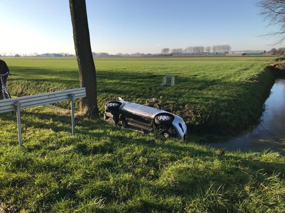 Auto met twee inzittende belande in water na ongeval..