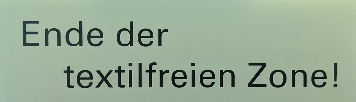 Schild mit Aufschrift: Ende der Textilfreien Zone