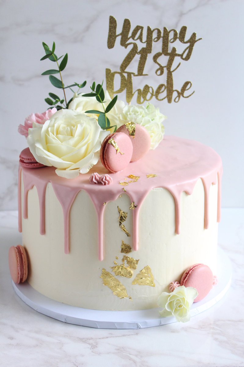HannahJBakes's tweet photo. A white chocolate mud cake filled with maple caramel, finished with a white chocolate ganache drip, macarons, gold leaf and fresh flowers 🌷🌿 Can I turn 21 again, please? https://t.co/uJRzjsfdFP