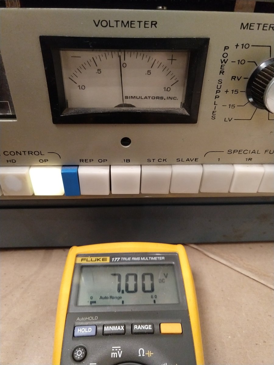 The meter of the analog computer shows 0.7V, while a multimeter shows 7.00 volts.