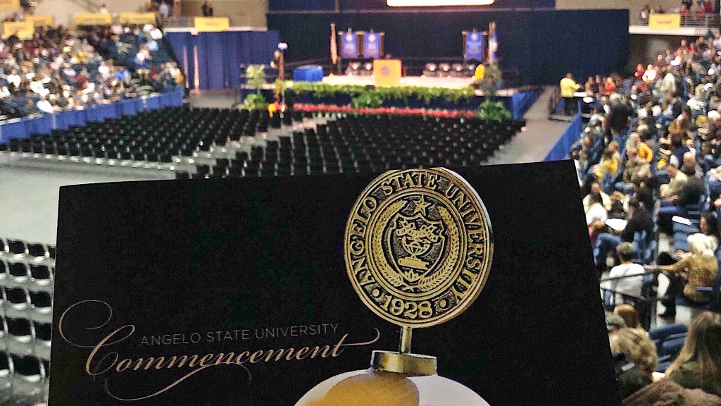 Graduation program with graduation stage in the background.