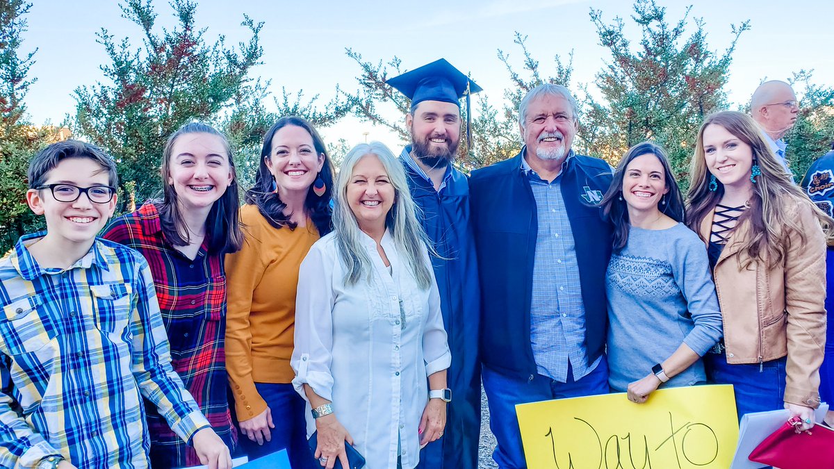 Family with graduate after college graduation ceremony.