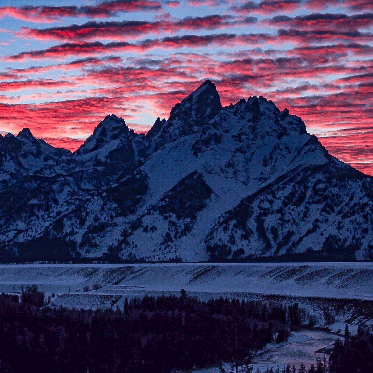 pink sky behind the snow-covered mountain range 