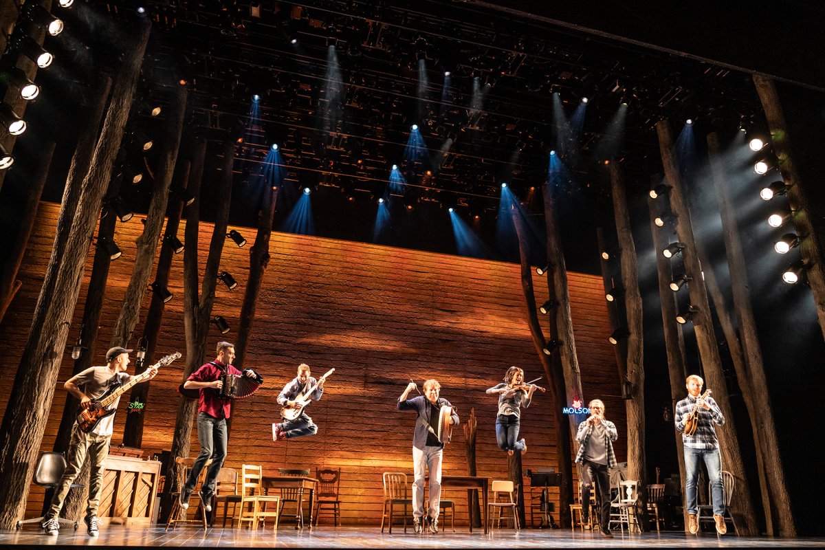 The band of Come From Away jumping holding their instruments