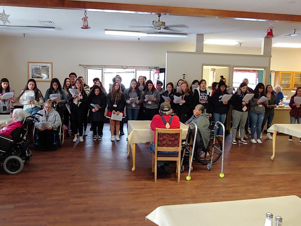 Choir members caroling at the nursing home. They also helped hand out gifts from Siouxland Federal Credit Union and cinnamon rolls to the residents.