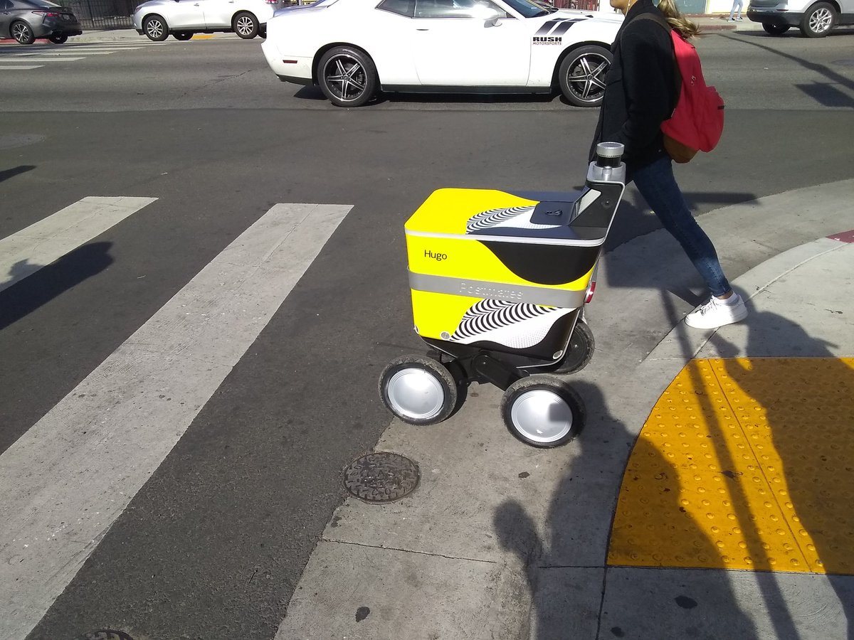tuser5555's tweet photo. @AndrewYang "Hugo" the PostMates delivery robot is v respectful for maintaining himself inside the crosswalk(unlike the 2 ppl taking pix of him - one is me lol)#UBI #YangGang #AndrewYang #Yang2020 #securethebag #securetheyang #YangGangLove #yangmediablackout #math #FreedomDividend #yangweek https://t.co/1nglqWdAmd
