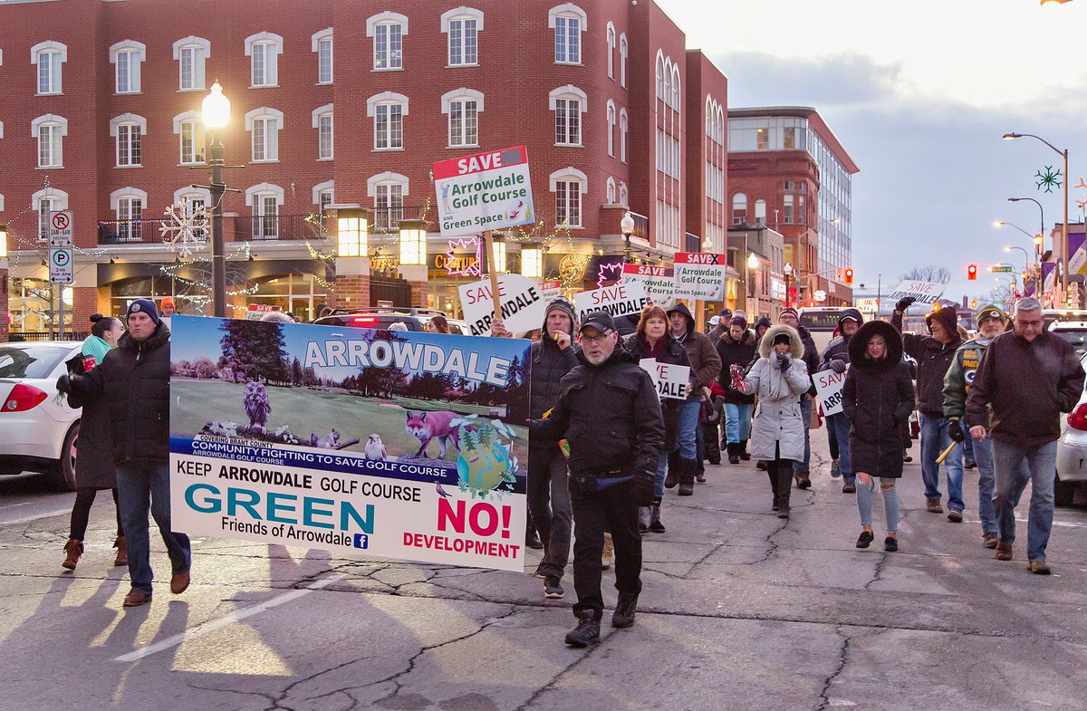 EXPbthompson's tweet photo. About 100 #Brantford residents, opposed to the proposed sale of municipally-owned #Arrowdale #Golf Course, march from Harmony Square to @CityofBrantford city hall where councillors will decide tonight on the contentious issue. @TheExpositor https://t.co/Qk6jvEi392