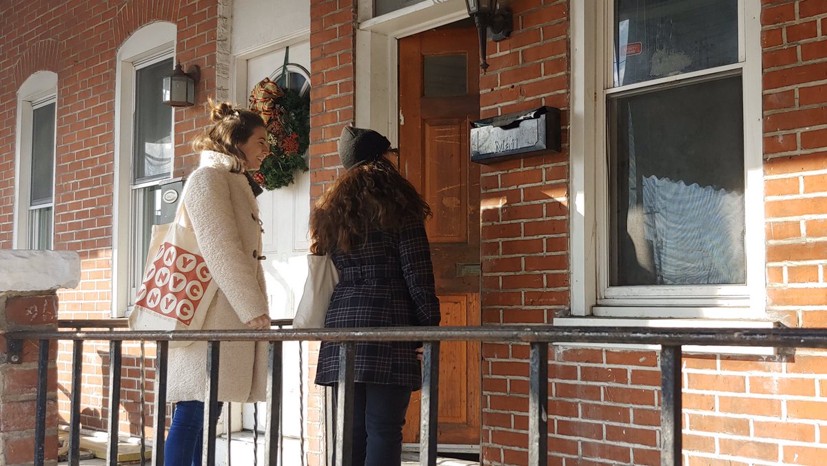 Jess Scarane and a volunteer knocking on a voter’s door