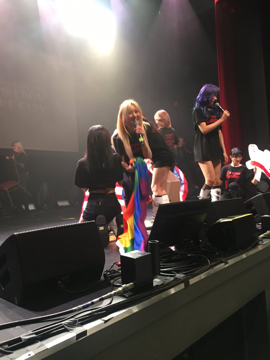 : Yoohyeon durante mais um show da turnê nos EUA recebendo outra bandeira LGBT.