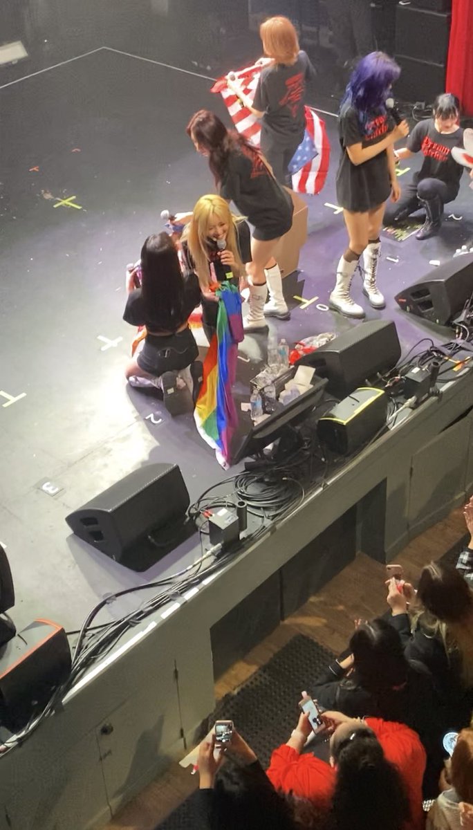 : Yoohyeon durante mais um show da turnê nos EUA recebendo outra bandeira LGBT.