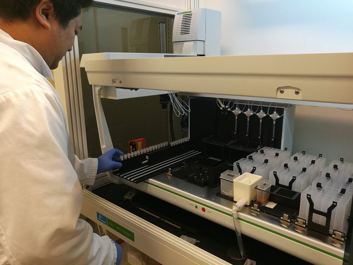 Työtekijä DNA-eristysrobotin luona.