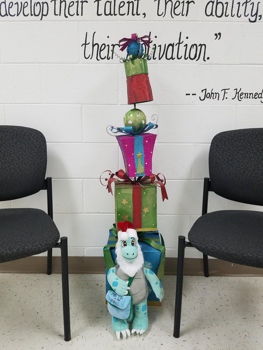 MathintheMail's tweet photo. How many gifts do you count behind Tre? How tall do you think the pile is? What could you use to measure it? #MathintheMail #Trelovesmath https://t.co/S71XCWT55N