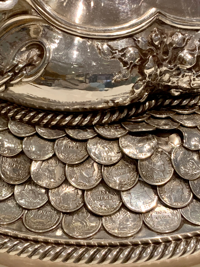 RISDMuseum's tweet photo. Crew deinstalling the largest silver object in our #GorhamSilver exhibition, the Dewey Cup. The #trophy & base are in 4 parts, and once it was taken down, you can see the silver dimes used as decoration, an homage to the 70,000 silver dimes melted down to make the piece! https://t.co/Nx36CM7Iz7