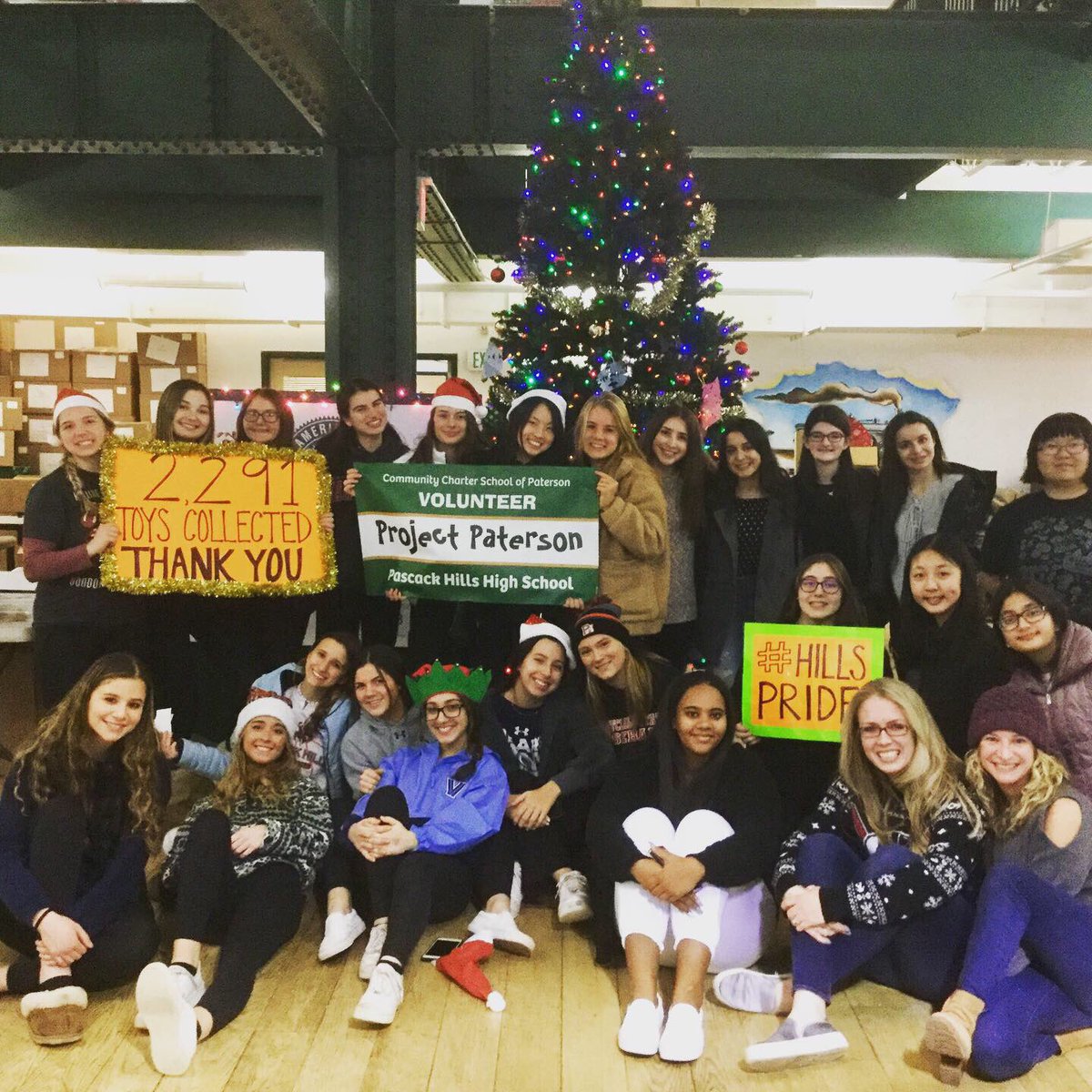 NJCDC's tweet photo. Pascack Hills High School’s #ProjectPaterson club returned to our headquarters today to sort and wrap more of the 2,291 toys they collected for our drive. We’ll give these toys to #Paterson children next week to make their holidays extra special! @PHHS_Teacher https://t.co/DrmT24UXf6