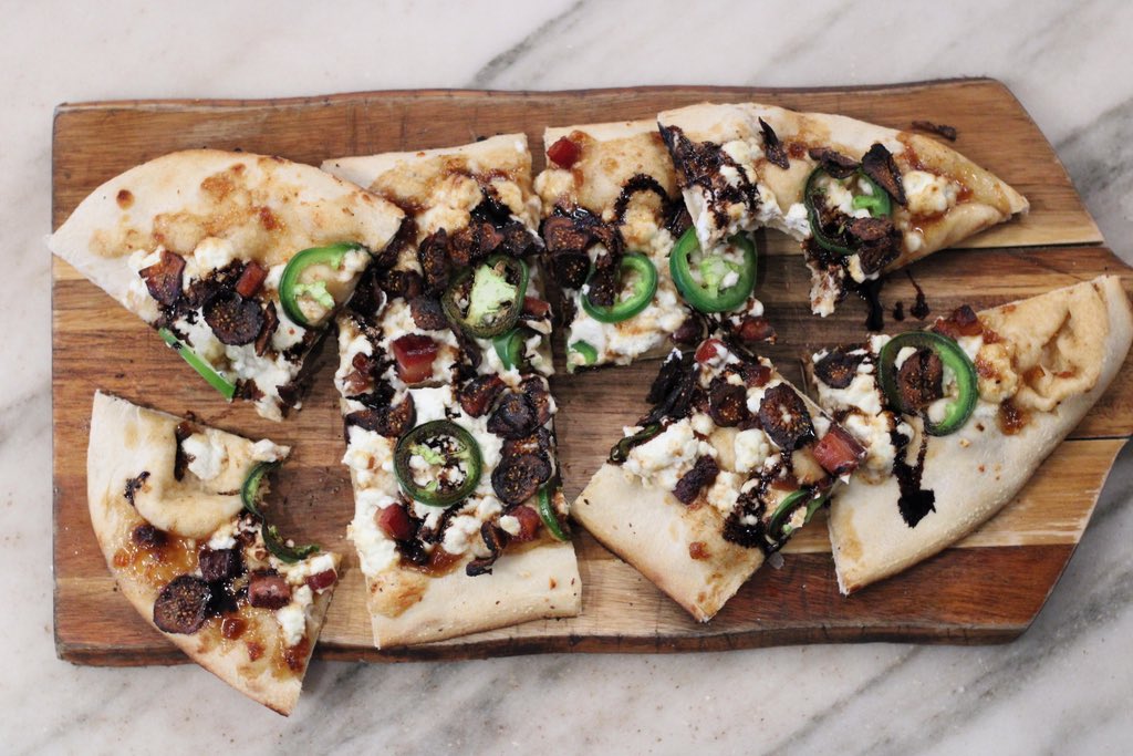 Our Fig and Goat Cheese Pizza features @riverbearamericanmeats lardon, sliced jalepeno, fig jam, and @haystack_mountain goat cheese. Try it for dinner, or to share 7 nights a week starting at 5 pm. 

#emporiumkitchenandwinemarket #emporiumfortcollins