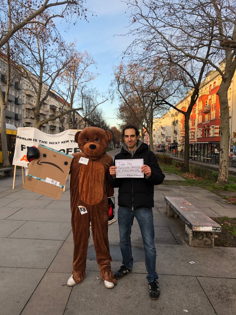 berlinvsamazon's tweet image. 100+Leute bei unserem ersten Aktionstag gegen den geplanten #amazon-Tower in #Berlin. Nachdem unser Bär den Turm aus Amazon-Paketen symbolisch umboxte🥊, posiert er nun mit Kundgebungsteilnehmer*innen und deren Messages gegen Amazon. 📢✊🏿👇🏽#BerlinVsAmazon #fightthetower