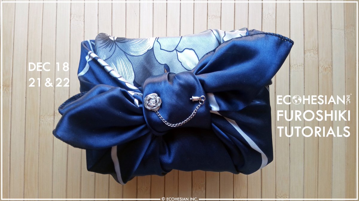 Colour photograph of a box gift wrapped in zero-waste Furoshiki reusable upcycled satin cloth with navy blue floral print, embellished with a silver floral brooch. On top of a bamboo placemat. On the right, is a white "Ecohesian Inc." trademarked logo, with an Earth as the letter "O", with white text below reading "Furoshiki Tutorials". On the left, white text reads "Dec 18, 21, & 22". At the bottom reads © Ecohesian