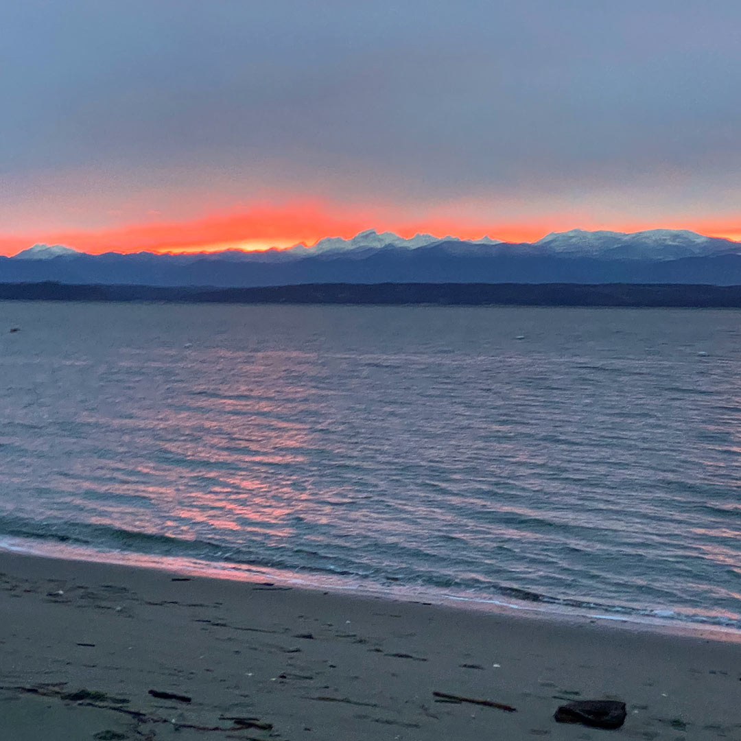 GoWhidbeyCamano's tweet photo. A gray day finishes with a flourish! It seems like the #Olympics are glowing! #DriveOffTheMainland #Whidbey https://t.co/KgP8rDBYml