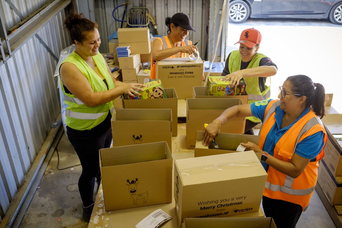 four women packing boxes with gifts for children in need