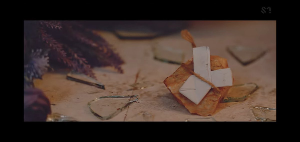 107.3. That is why she is calling Yeri. To help her to be free. And as you can see here. Yeri is holding a rock with something around it. And throws it against the mirror. Where Seulgi is looking. Look at the rock, it has a paper folded to white ribbon. Meaning peace. She..