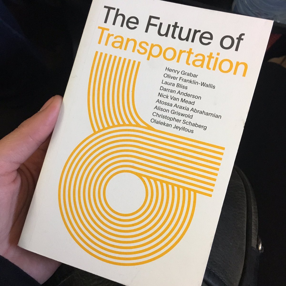 Picture of the book ‘The Future of Transportation’. The book has white cover with an yellow abstract design. The book is an edited collection with chapters by the following authors: Graber, Franklin-Wallis, Bliss, Anderson, Van Mead, Araxia Abrahamian, Griswold, Schaberg and Jeyifous.