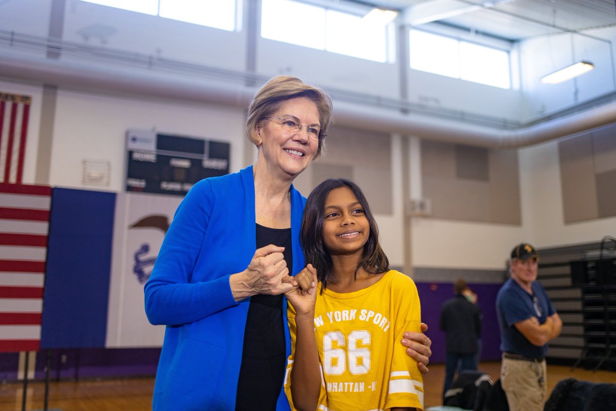 Elizabeth Warren makes a pinkie promise with a young girl at the North Liberty, Iowa town hall.