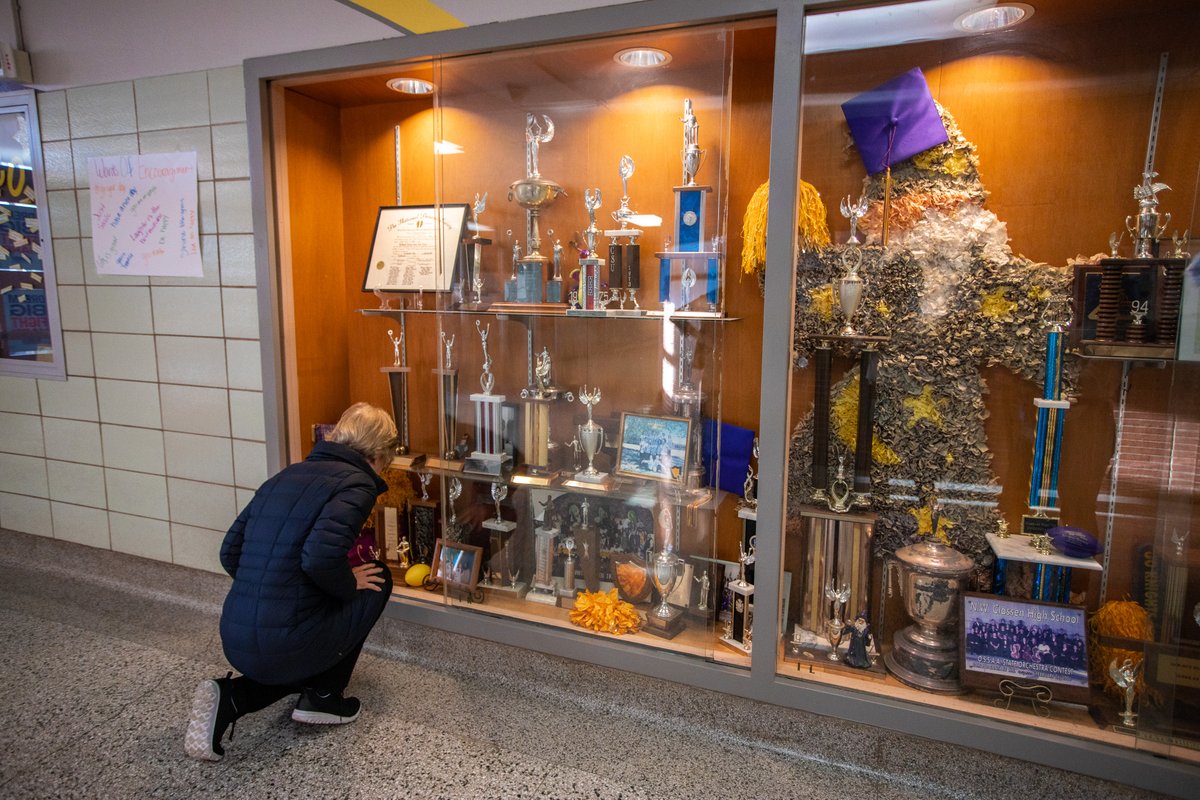 Elizabeth Warren looks at her high school debate trophy.