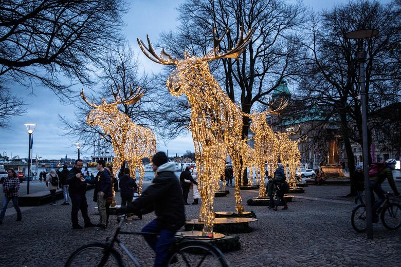DukaKofi's tweet photo. People stroll among Christmas light installations formed as elks at the Raoul Wallenberg Square in central Stockholm, Sweden https://t.co/fxaXu5v8tS