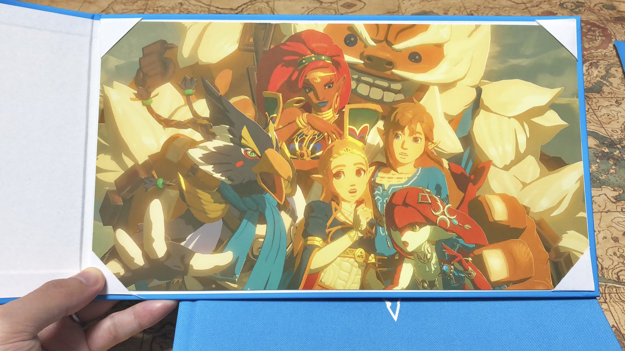 カオキ 海外版マスターワークスの充実度がすごいのでもう一回紹介 日本版と違い 本が英傑ブルーの布張りで豪華 中身はもちろん 英語 ポーチのツイートにもある克服の証ガラス球は このオマケです 他に英傑の詩の集合写真と ハイラル全土のデカい