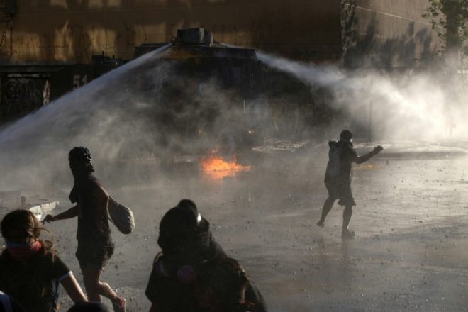 RadioPuntoGT's tweet photo. #ProtestasEnChile | Las protestas y los enfrentamientos entre la policía y manifestantes volvieron este viernes a copar la plaza Italia de Santiago, epicentro de la revuelta social que vive Chile, con una movilización encabezada por estudiantes. https://t.co/GfBsw29AL6