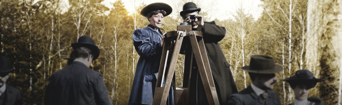 Edwardian man and woman on step ladder looking through camera