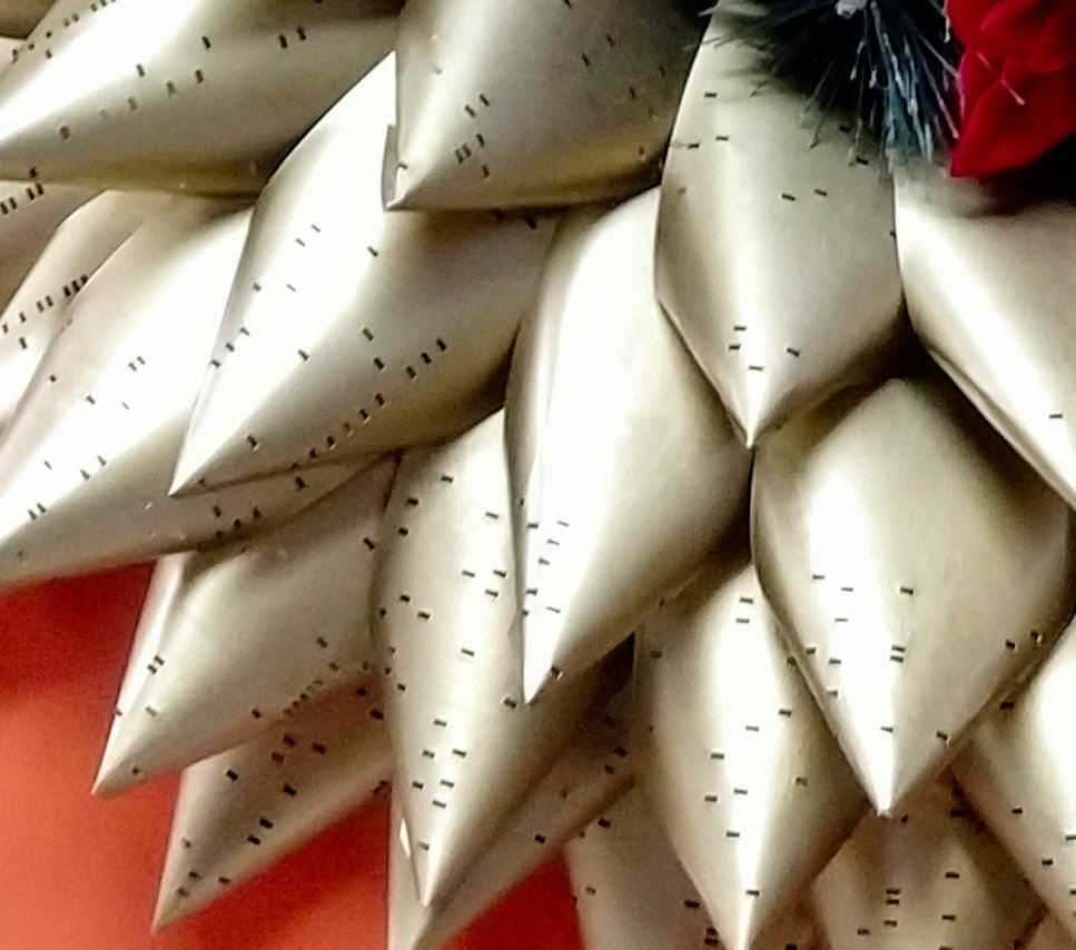 A closeup of the wreath, showing punch cards with holes.