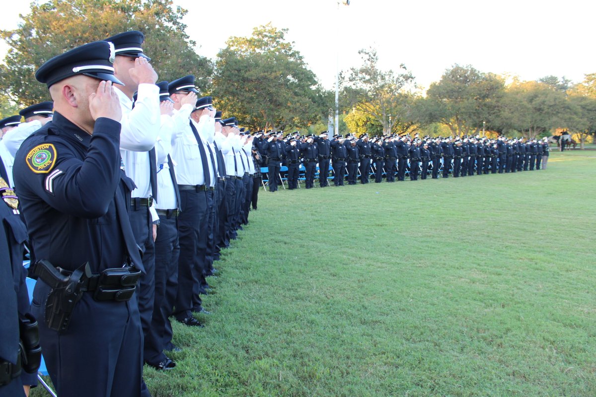 rows of HPD officers and cadets saluting in a field