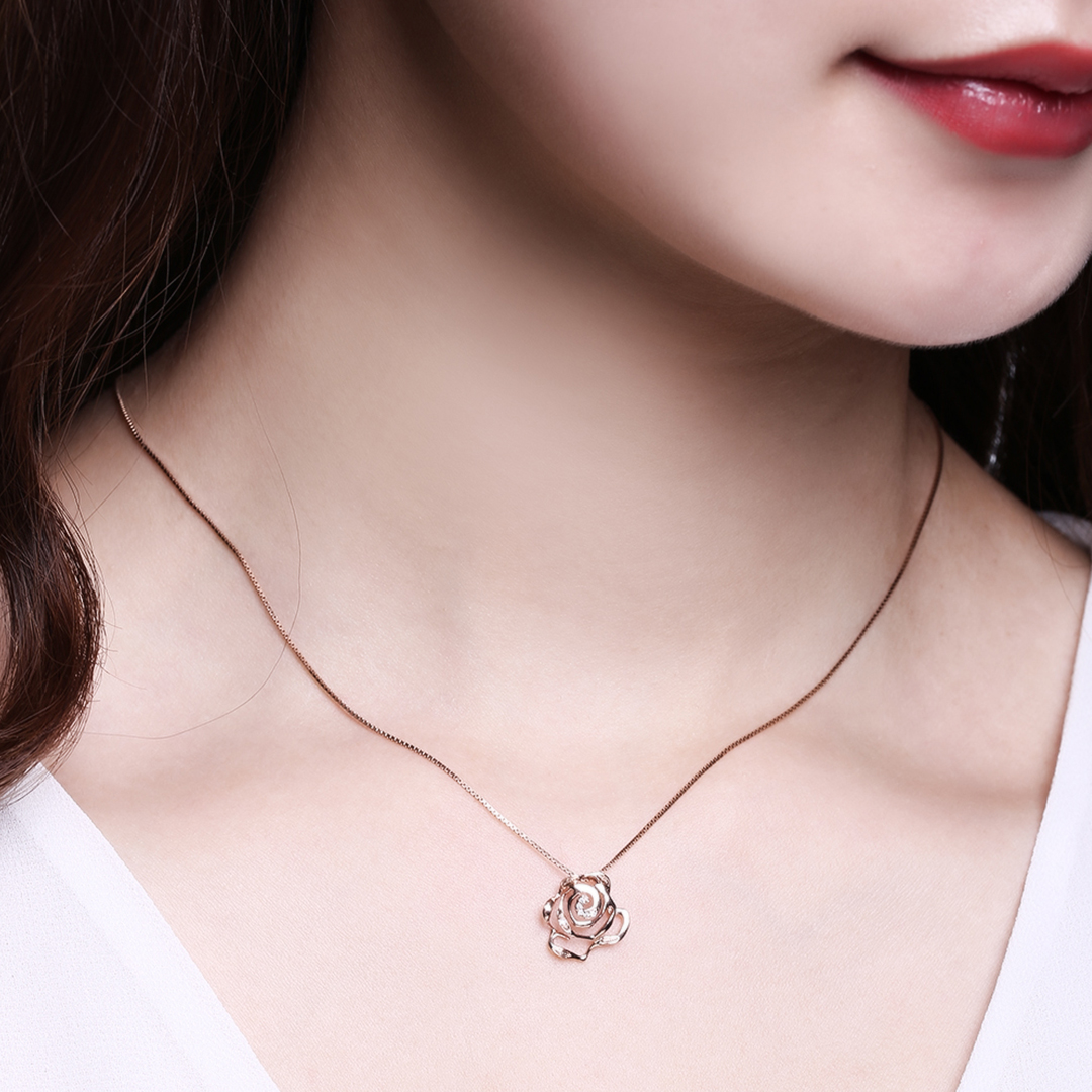 Lady wearing Fei Liu's Rose Stud Pendant in 18ct rose gold plate on sterling silver set with cubic zirconia.