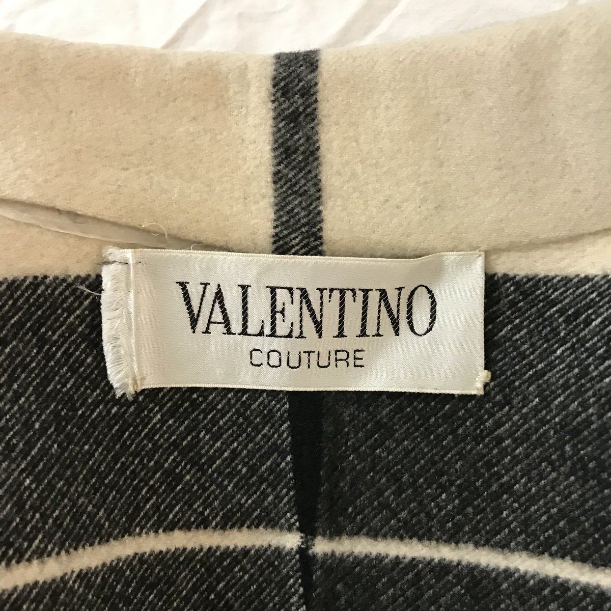 A close-up view of the interior of a black and cream coat from Valentino Couture.